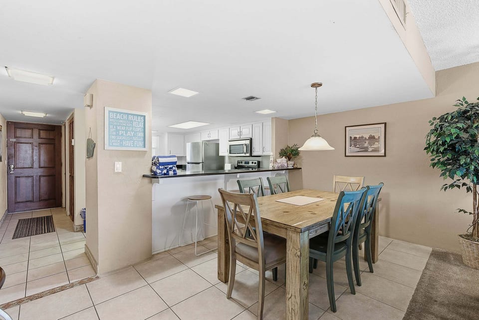 Gather for meals during your beach stay in this inviting dining area with seating for all and a convenient breakfast bar. The open layout connects seamlessly to the kitchen, perfect for easy coastal living and entertaining.