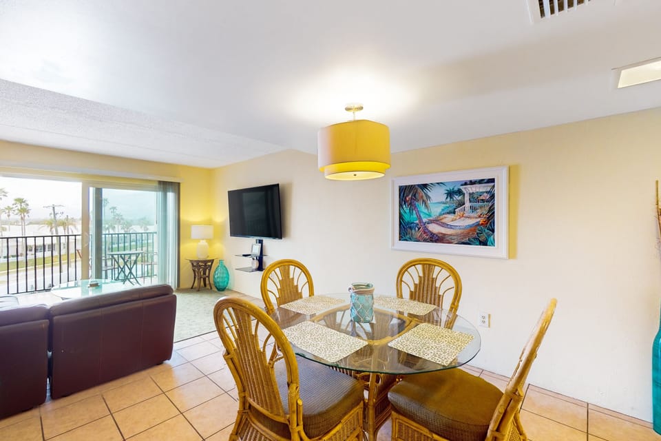 Gather in this charming beach stay dining area featuring coastal décor and easy access to the living space and balcony. Enjoy meals together before heading out to soak up the sun and sea breeze at the beach.