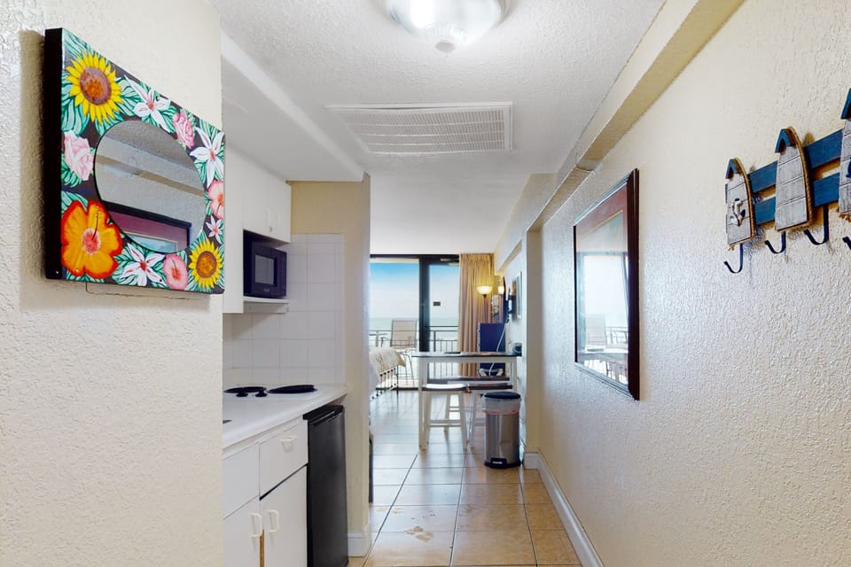Step into this welcoming entryway featuring a convenient kitchenette and coastal décor. Designed for an easy, comfortable beach stay, it leads you straight to ocean views, relaxing living space, and sandy adventures.