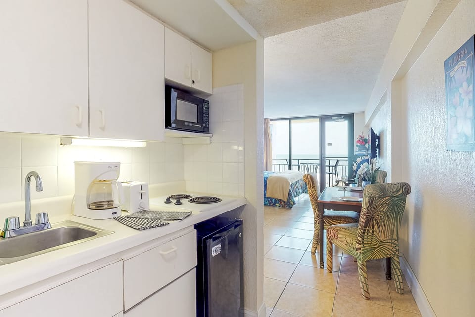 This beachside kitchenette and dining area offers everything you need for a relaxing beach stay. Enjoy easy meals, coastal décor, and a view leading to the ocean—perfect for mornings before the sand and surf.