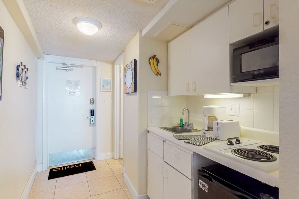 This convenient beachside kitchenette offers everything you need during your beach stay, including a cooktop, microwave, and coffee maker—perfect for quick bites before heading out to the sand and sea.