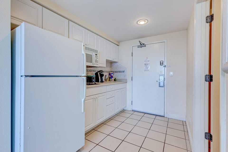 This handy beach-stay kitchenette offers a full fridge, microwave, and counter space—perfect for quick meals and added convenience during your coastal getaway.