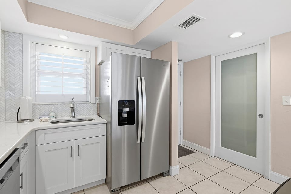 Designed for an easy beach stay, this bright coastal kitchen features modern appliances, clean finishes, and convenient prep space—perfect for quick bites or relaxed meals after a day at the beach.