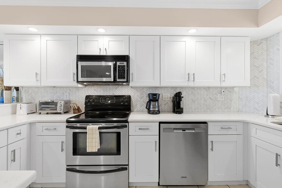 Make your beach stay effortless in this fully equipped coastal kitchen. Featuring modern appliances, ample counter space, and bright finishes, it's ideal for cooking, dining, and relaxing during your beach vacation.