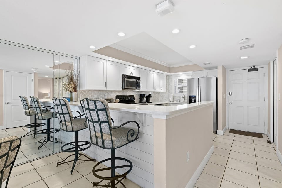 Enhance your beach stay in this stylish, fully equipped coastal kitchen. Featuring a spacious breakfast bar and modern appliances, it's perfect for casual meals, entertaining, and relaxed beach vacation living.