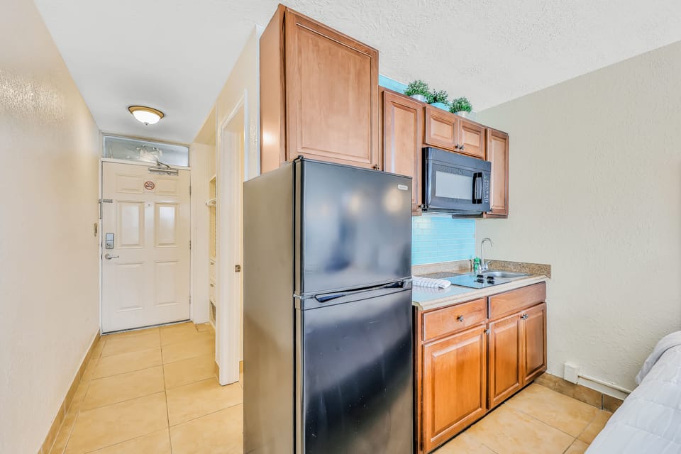 Bright, functional kitchenette with full-size fridge, cooktop, and microwave. Perfect for an easy beach stay, offering simple meal prep and comfort just steps from the ocean.
