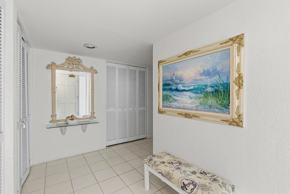 Step into a bright, welcoming entryway featuring coastal artwork and thoughtful touches that set the tone for a relaxing beach stay. This inviting space offers convenient storage and a calm seaside vibe from the moment you arrive.