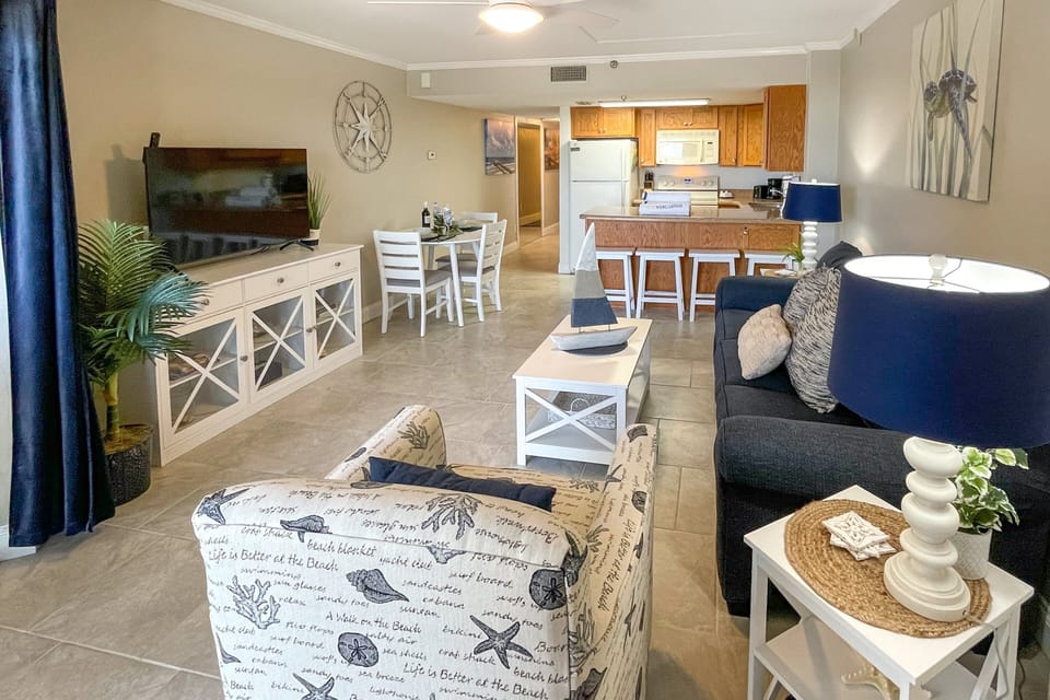 Settle into this spacious coastal living area featuring comfortable seating, dining space, and a full kitchen. Ideal for a relaxing beach stay, with an open layout perfect for unwinding after sun-filled days by the shore.