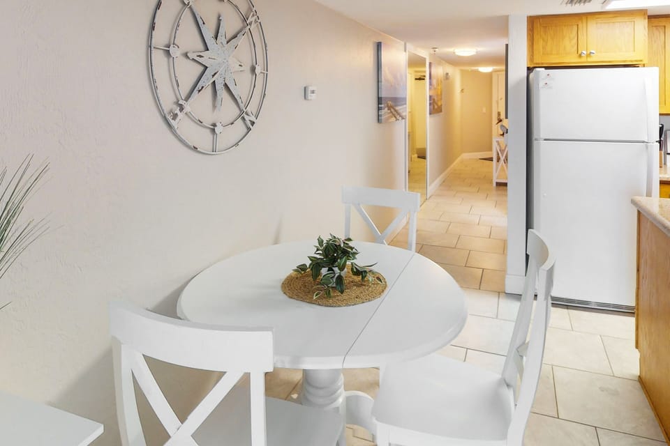 Enjoy meals during your beach stay in this charming coastal dining nook, featuring bright décor and easy access to the kitchen—perfect for casual breakfasts or relaxing dinners after a day by the ocean.