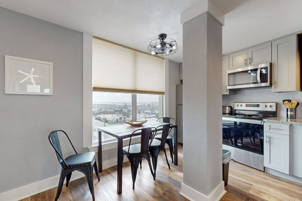 Light-filled dining space with modern seating and scenic coastal views, perfect for meals during your beach stay. Enjoy morning coffee or family dinners while soaking in the relaxed seaside atmosphere.