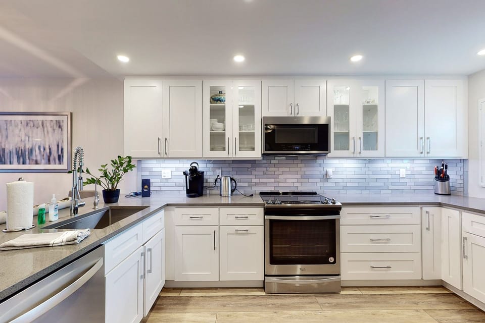 This modern coastal kitchen features stainless steel appliances, ample counter space, and stylish finishes—perfect for preparing meals during your beach stay and enjoying relaxed, resort-style living steps from the shore.