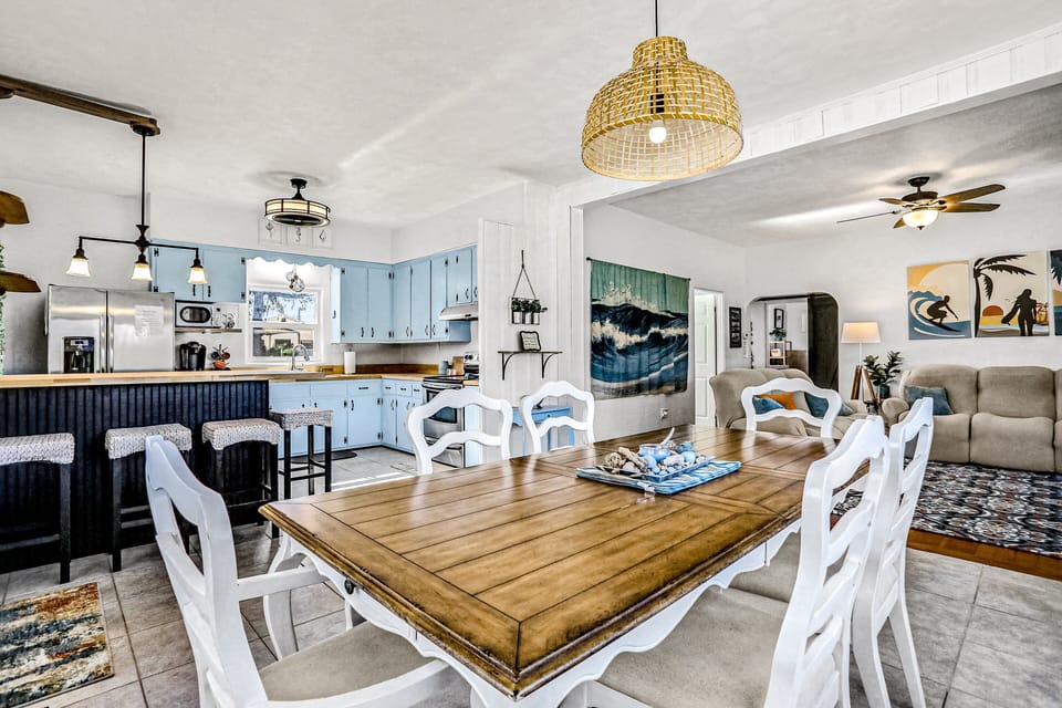 Enjoy a bright, beach-inspired dining and kitchen space perfect for gathering after a day by the ocean. This open layout features coastal décor, ample seating, and a fully equipped kitchen for the ideal beach stay.