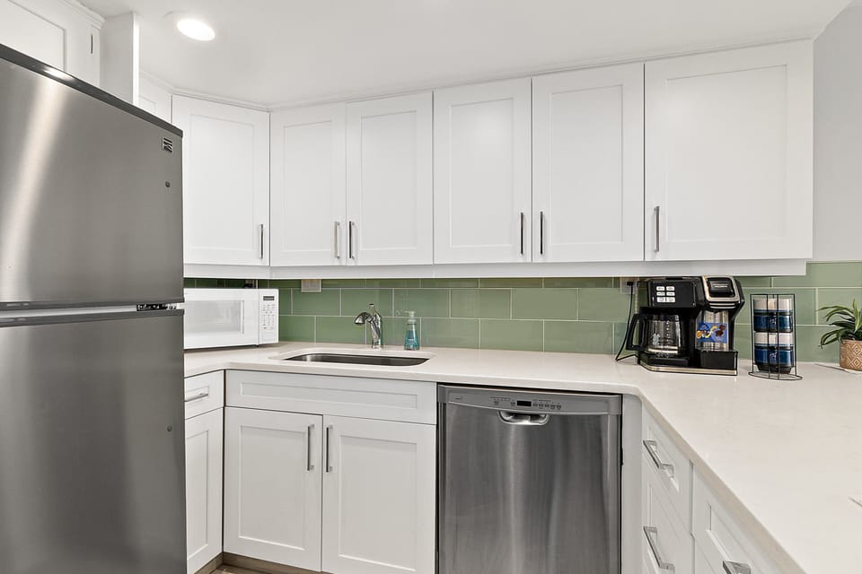 This bright coastal kitchen features modern appliances, ample cabinetry, and clean finishes—perfect for easy meals during your beach stay. A functional, stylish space designed to make your seaside vacation both relaxing and convenient.