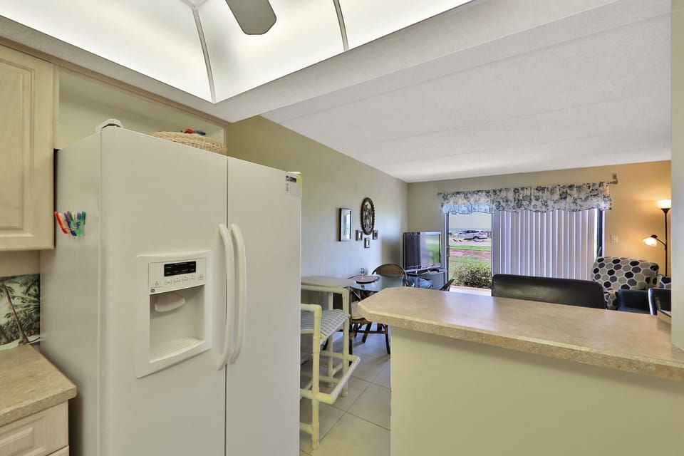 Bright kitchen with breakfast bar overlooking the dining and living areas. Perfect for gathering, dining, and enjoying easy living during your beach stay just moments from sun and sand.