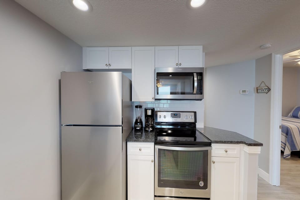 This modern beach stay kitchen features stainless appliances, ample storage, and essential cookware—making meal prep easy and convenient during your relaxing coastal getaway.