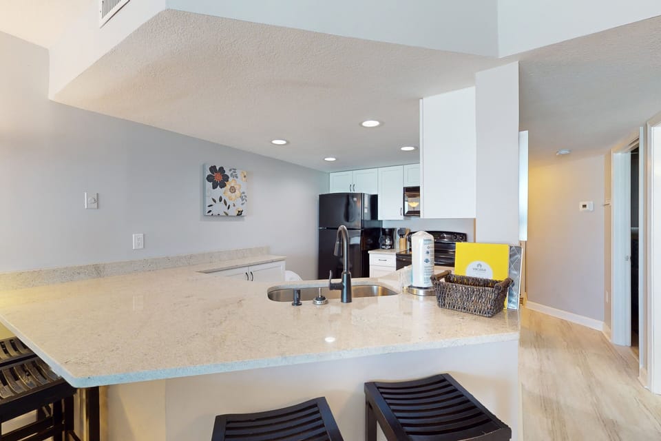 Inviting beach-stay kitchen bar with ample counter space and seating, perfect for casual dining or gathering after a day by the ocean.