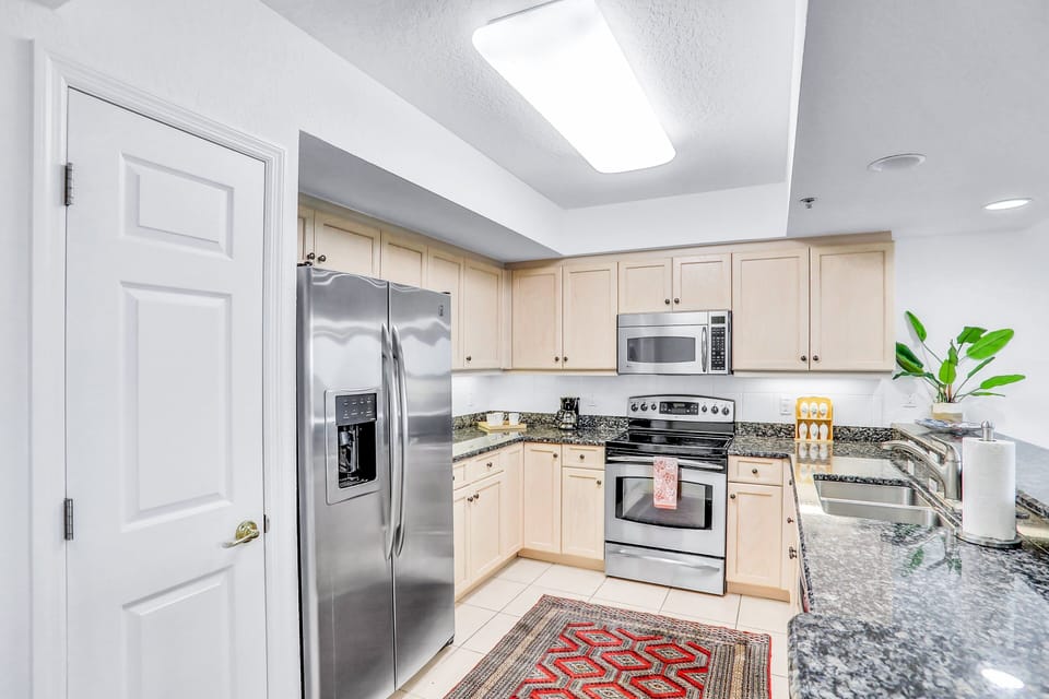 This bright kitchen features stainless steel appliances and ample counter space for easy meal prep. Ideal for your beach stay, it's perfect for cooking and gathering after days spent by the ocean.