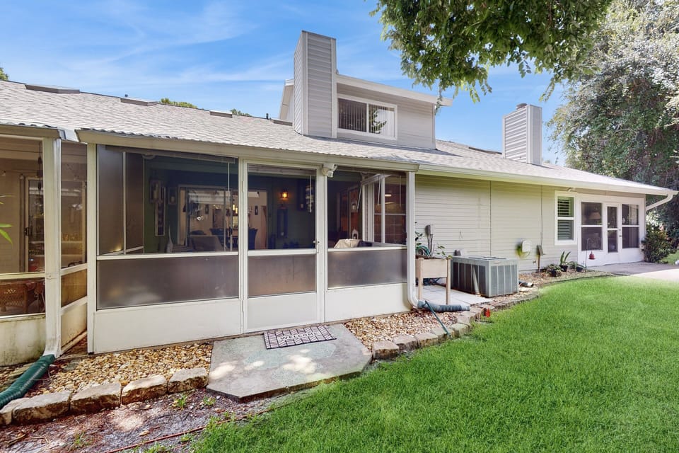 Enjoy a peaceful beach stay on this private screened patio, perfect for relaxing after a day of sun and surf. A quiet outdoor space surrounded by greenery adds comfort to your coastal getaway.