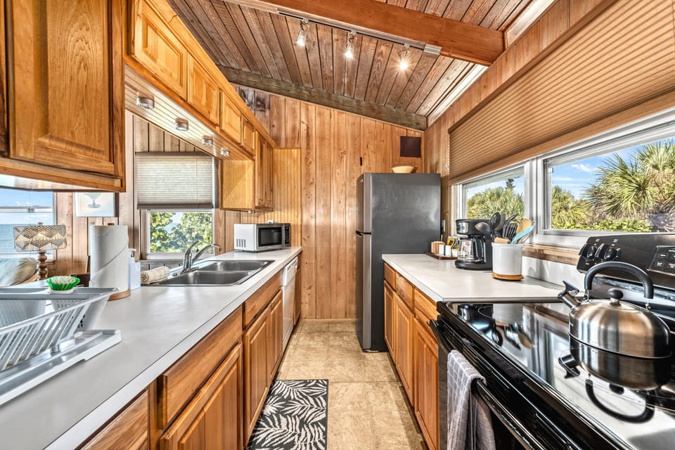 Spacious kitchen with full appliances, abundant natural light, and open layout connecting to the dining and living areas.