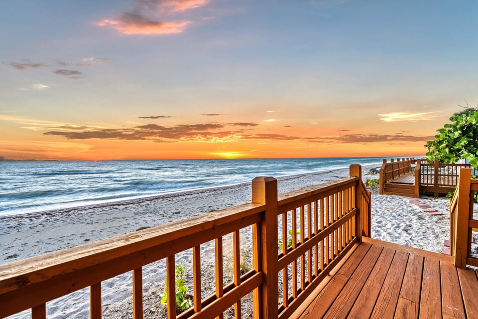 Golden light spills across the sand and water, with the Gulf stretching endlessly beneath a glowing sky.