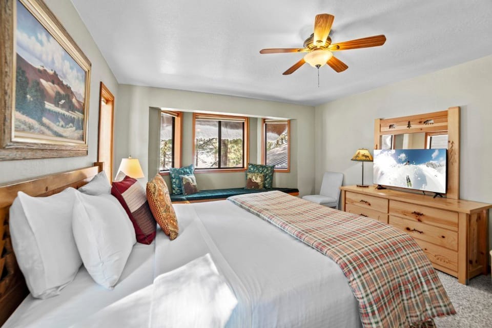 The spacious bedroom includes large windows with panoramic views and comfortable furnishings for a restful retreat.