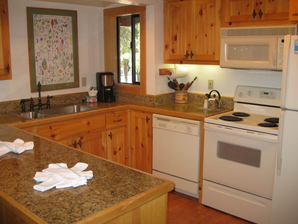 The fully equipped kitchen boasts beautiful wooden cabinetry and modern appliances, providing an inviting space for preparing meals after a day of adventure.