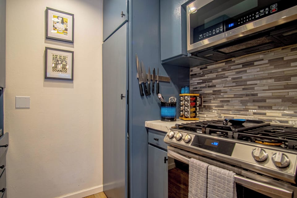 Fully equipped kitchen with a gas stove, plus a washer and dryer neatly tucked behind doors.