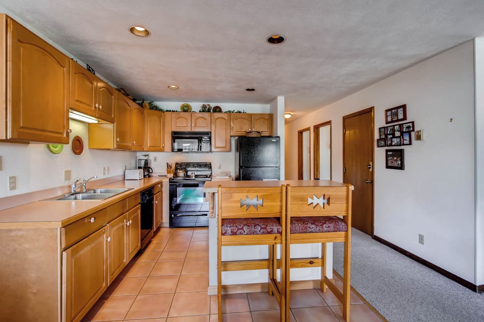 Cook up your favorite meals in the fully equipped kitchen featuring modern appliances and charming wooden cabinetry.