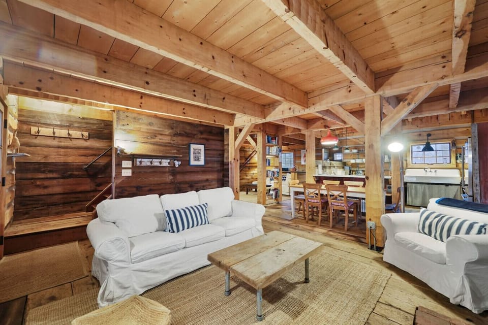 A charming corner of the living room with a cushioned sofa, art on the walls, and soft ambient lighting.