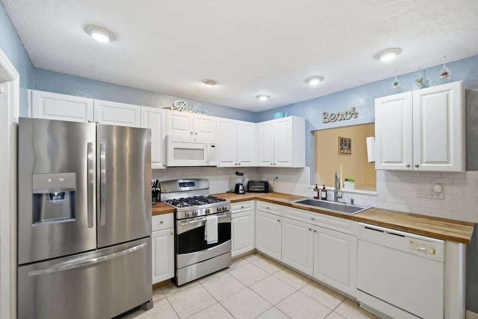 Bright, fully stocked kitchen with stainless appliances.