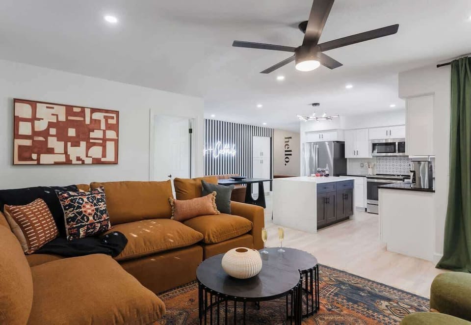 2nd living area with a smart TV, gas fireplace, designer sectional, comfy chairs, breakfast table, and private access to the patio.