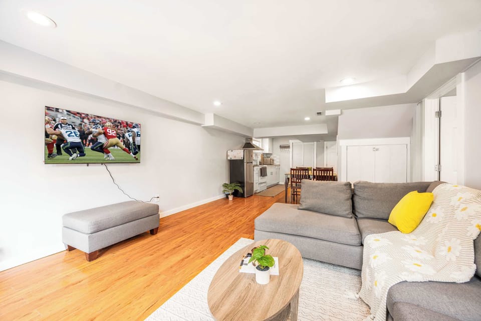Spacious and bright lounge with a comfy sectional and large smart TV—perfect for movie nights or sports fans.