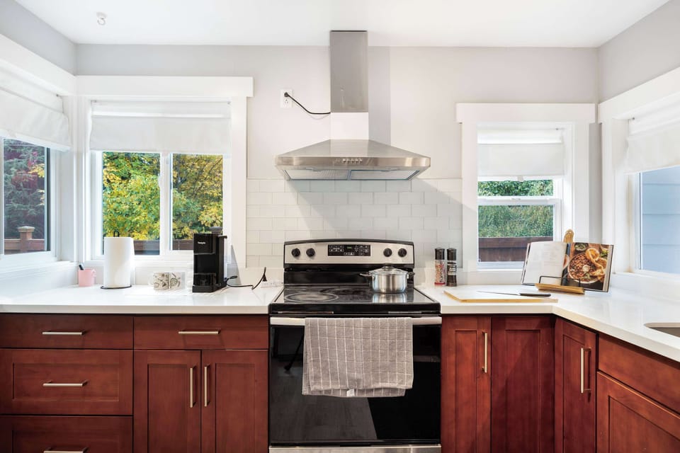 Modern range hood and double windows bring both functionality and charm to your cooking experience.