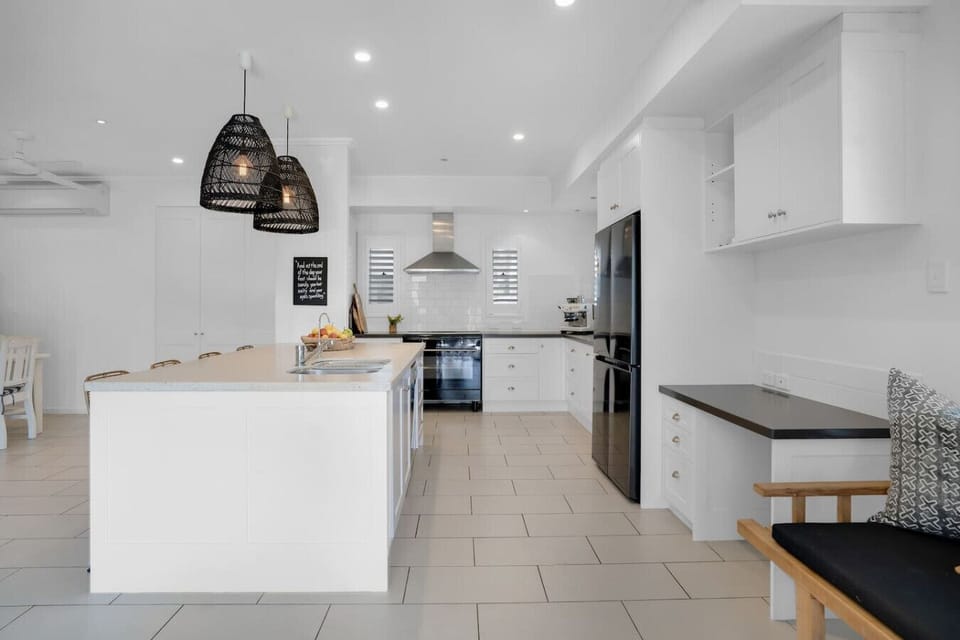 Fully equipped kitchen with island bench and espresso coffee machine