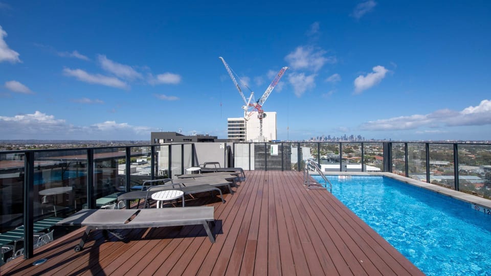 Rooftop pool with sun loungers and city views, perfect for relaxing under the sun.