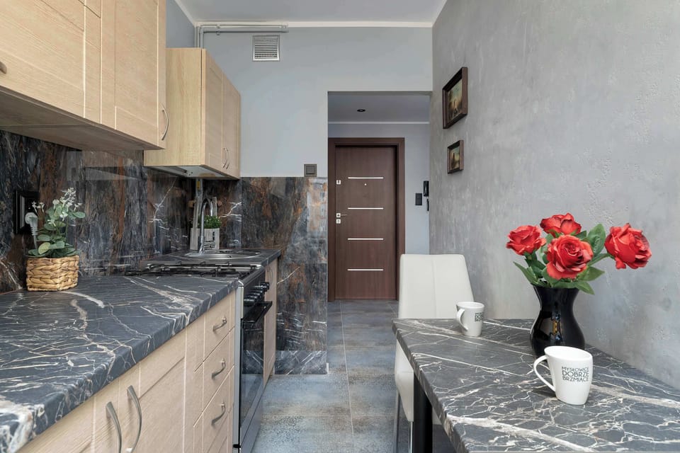 The marble countertop and fresh flowers elevate the kitchen’s look, turning everyday cooking into an enjoyable moment.
