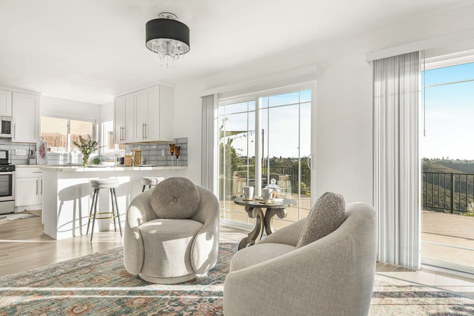 Open-concept kitchen and casual seating area with rounded armchairs and a small table.