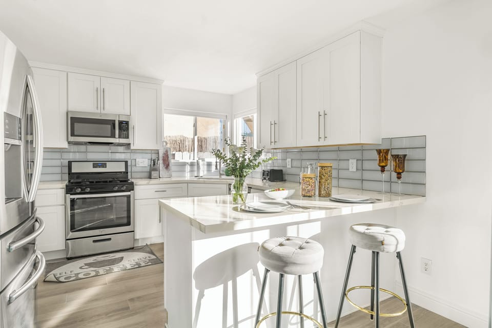 Bright, white kitchen with a large island and breakfast bar seating.