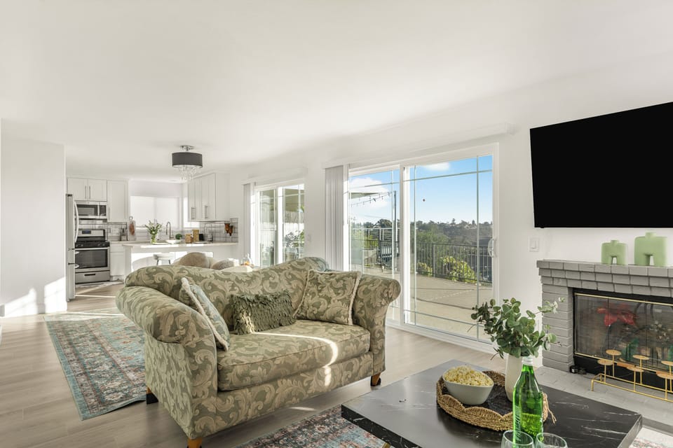 Wide view of the main living area emphasizing the large windows and comfortable seating.