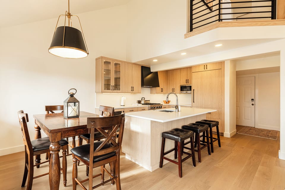 Bright open kitchen and dining area with vaulted ceilings.