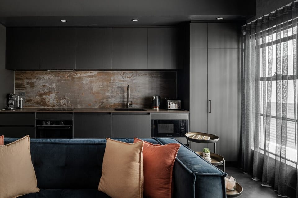 Open-plan living and kitchenette with designer finishes, modern appliances and soft furnishings that create a warm, stylish retreat