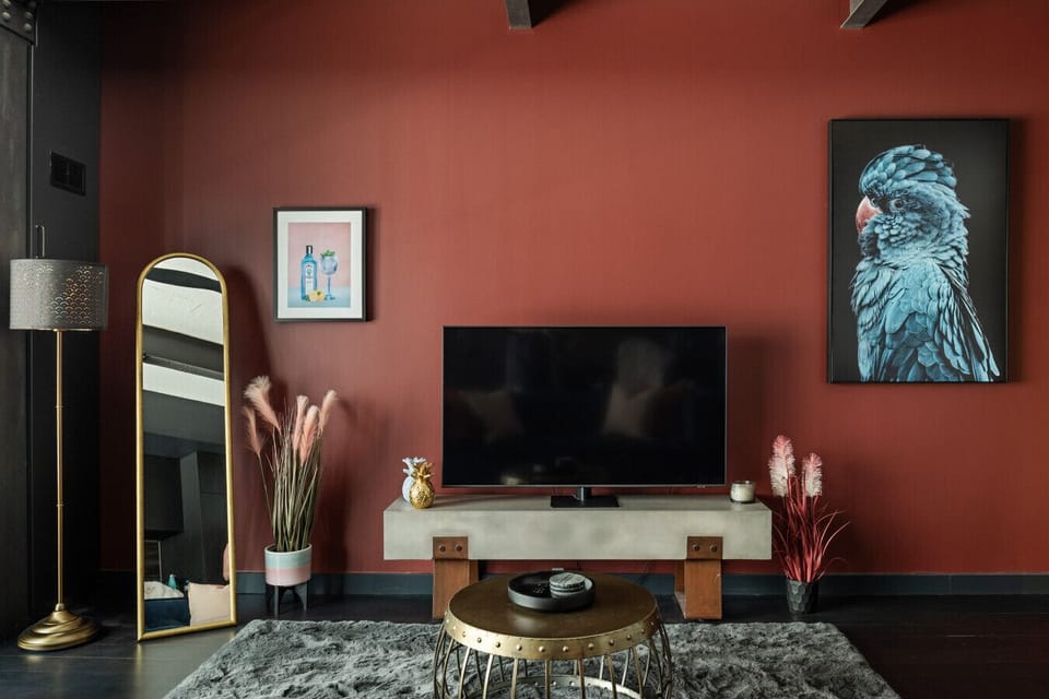 Elegantly styled living area showcasing a smart TV, striking artwork and layered, luxury finishes