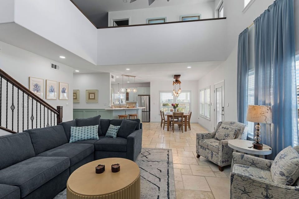 Unwind in your spacious living room where plush seating and coastal decor create the perfect gathering space for memorable evenings together.