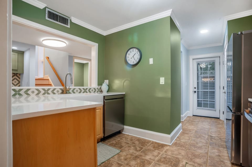 Your fully-equipped kitchen features modern appliances and cheerful green walls, creating a welcoming space to prepare meals during your stay.
