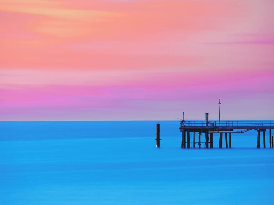 As the sky blushes into pinks and purples, the Glenelg Jetty becomes a front-row seat to the day’s most breathtaking moment.