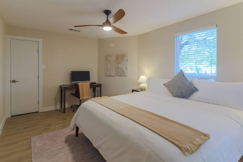 Guest Bedroom (end of the house): Leesa Sapira Chill Hybrid king bed with work-from-home setup, including desk, monitor, mouse, and docking station. Closet with portable fan, books, board games, luggage rack, sleeping machine, ear plugs, and extra be