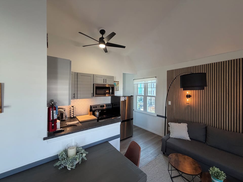 Modern studio-style living with sleek kitchen, high ceilings, and cozy lounge