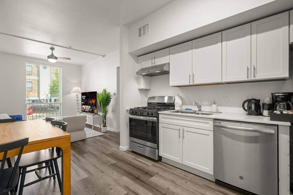 Fully equipped kitchen with gas range, dishwasher, and coffee setup opens to a bright dining and lounge area. Cook, connect, and recharge in the heart of West Campus