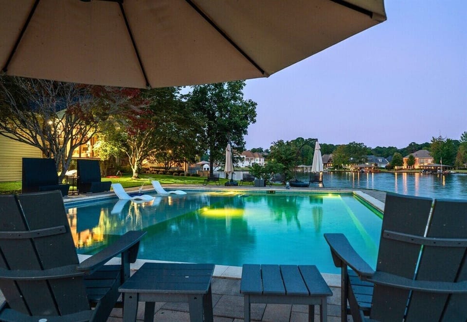 Poolside seating at dusk with peaceful lakefront ambiance.