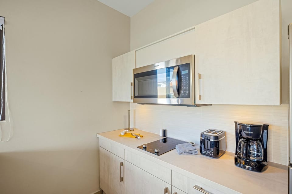 Whether you're brewing your morning coffee or heating up a late-night snack, our modern amenities make it easy. We include the essentials: coffee maker, toaster, microwave, and cooktop. Simple, stylish, and ready for you.